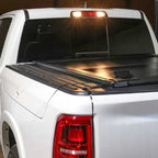 White truck with a black tonneau cover on a dark background