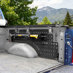 Truck bed with bed side molle panel system and Dewalt tool, mountainous landscape in the background