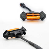 Two motorcycle turn signals with orange lenses on a white background