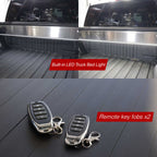 Built-in LED truck bed light and remote key fobs on a truck bed floor.