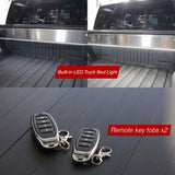 Built-in LED truck bed light and remote key fobs on a truck bed floor.