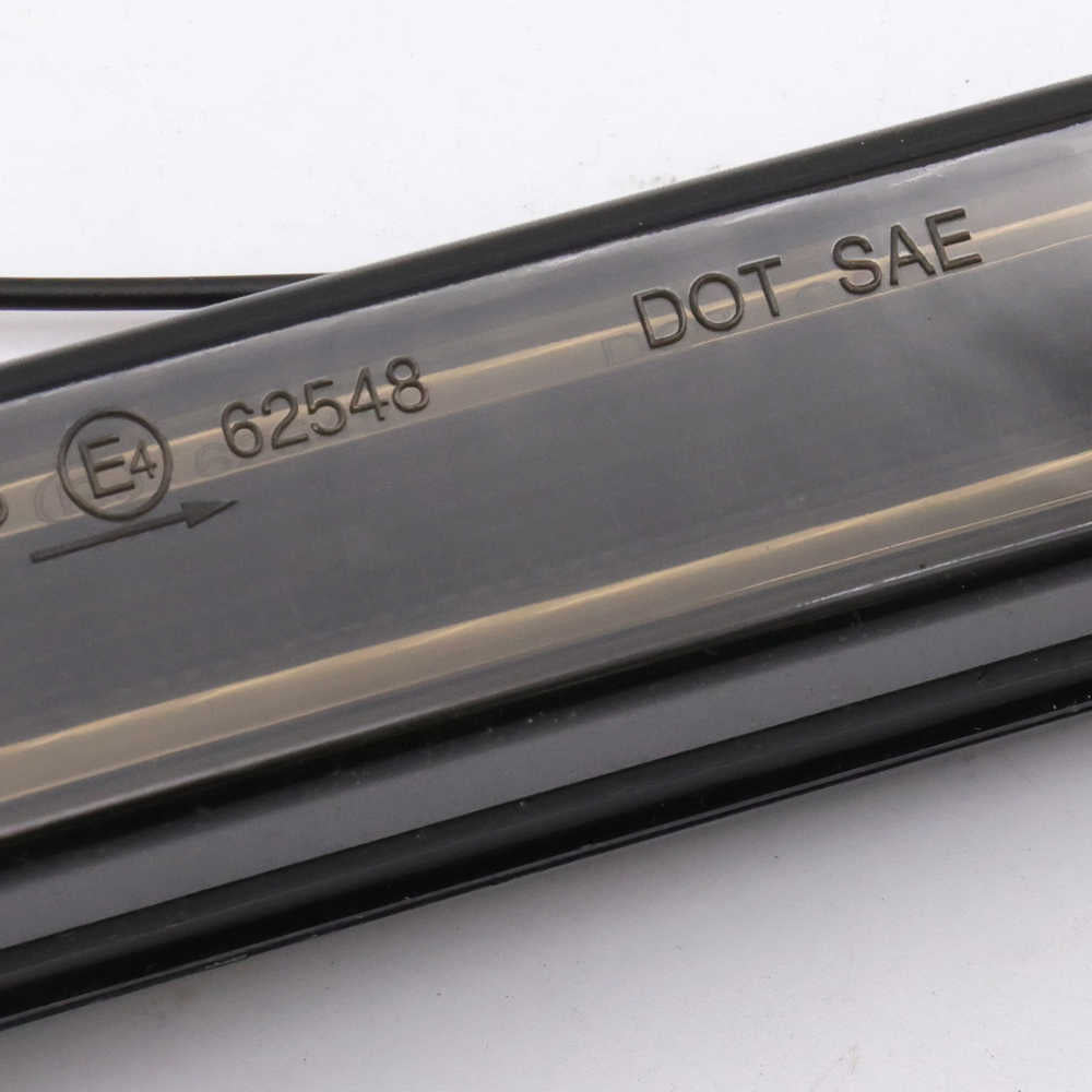 Close-up of a transparent automotive windshield washer fluid reservoir tube with embossed DOT SAE certification markings and a production code 62548.