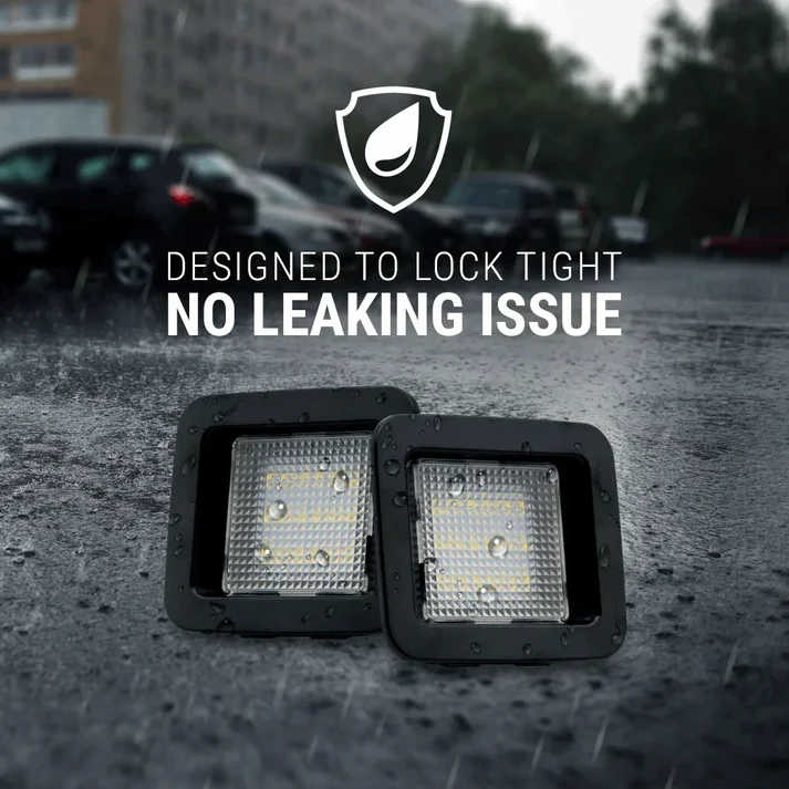 Two square black LED light fixtures shown on wet pavement with overlaid marketing text reading 'DESIGNED TO LOCK TIGHT' and 'NO LEAKING ISSUE,' plus a shield icon. A real outdoor rainy environment and blurred cars are visible in the background, so this is Lifestyle rather than Product/Packaging.