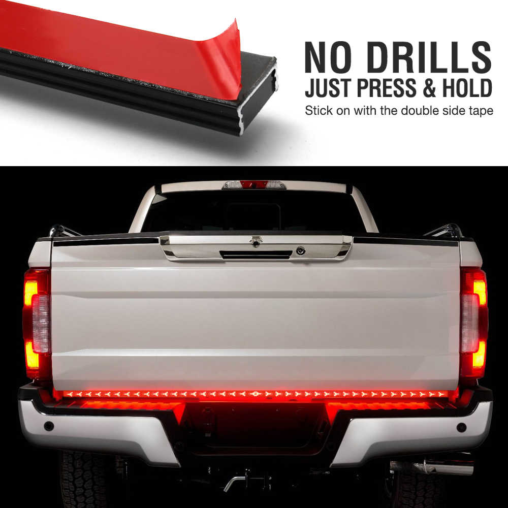 LED truck bed light bar shown installed on the rear of a white pickup truck, with a top inset showing the red-and-black adhesive strip and text reading 'NO DRILLS JUST PRESS & HOLD Stick on with the double side tape.'.