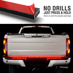 LED truck bed light bar shown installed on the rear of a white pickup truck, with a top inset showing the red-and-black adhesive strip and text reading 'NO DRILLS JUST PRESS & HOLD Stick on with the double side tape.'.