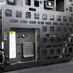 Close-up of a component with a green light and labels on a dark background