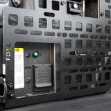 Close-up of a component with a green light and labels on a dark background
