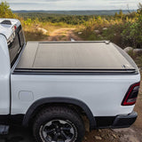 White truck with a tonneau cover on a dirt road in a natural landscape
