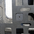 Close-up of a textured metal surface with a square hole