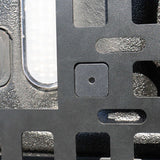 Close-up of a textured metal surface with a square hole