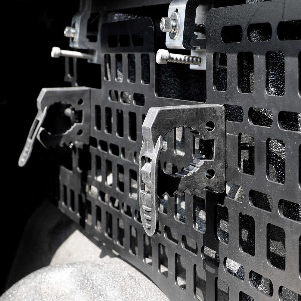 Close-up of a metal molle panel with bolts on a dark background