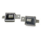 Two rectangular LED license plate lights with gray metal mounting brackets, shown on a plain white background.