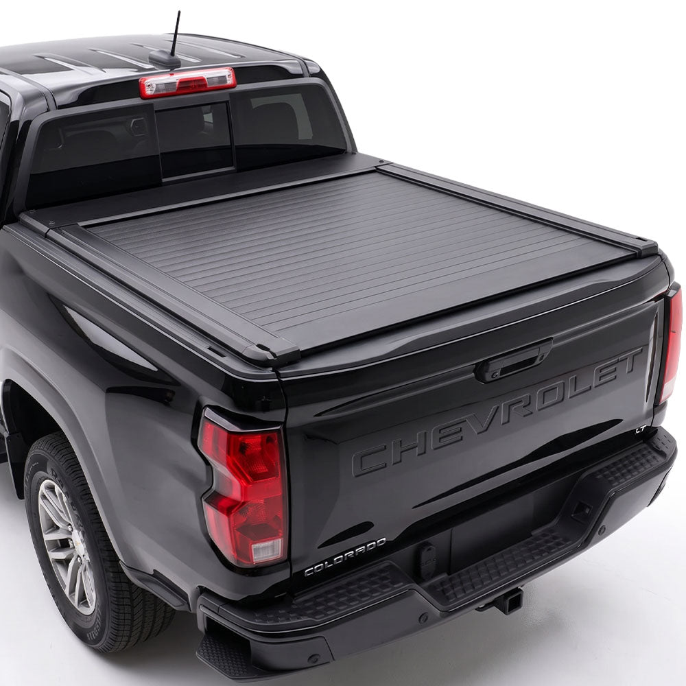A truck bed cover installed on the bed of a black Chevrolet Colorado pickup truck.