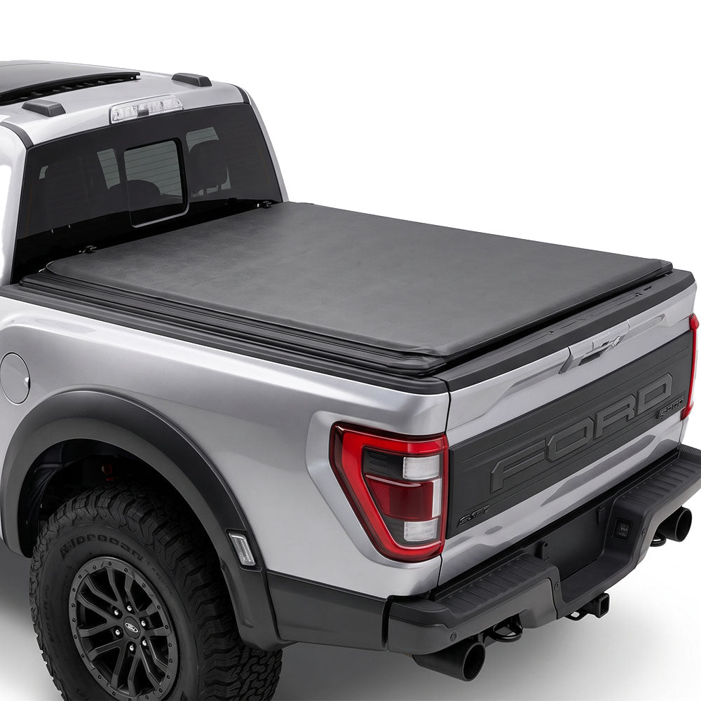 Silver truck with a soft roll up tonneau cover on a white background.