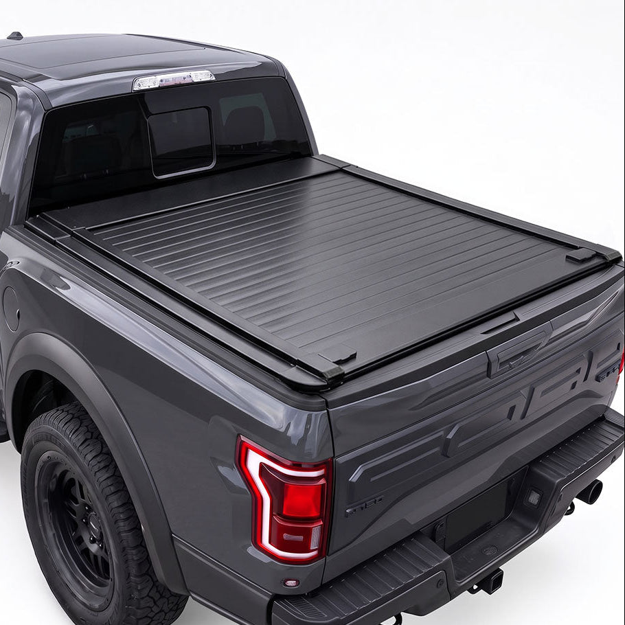 A black retractable truck bed cover installed on the bed of a dark gray F-150 pickup truck.