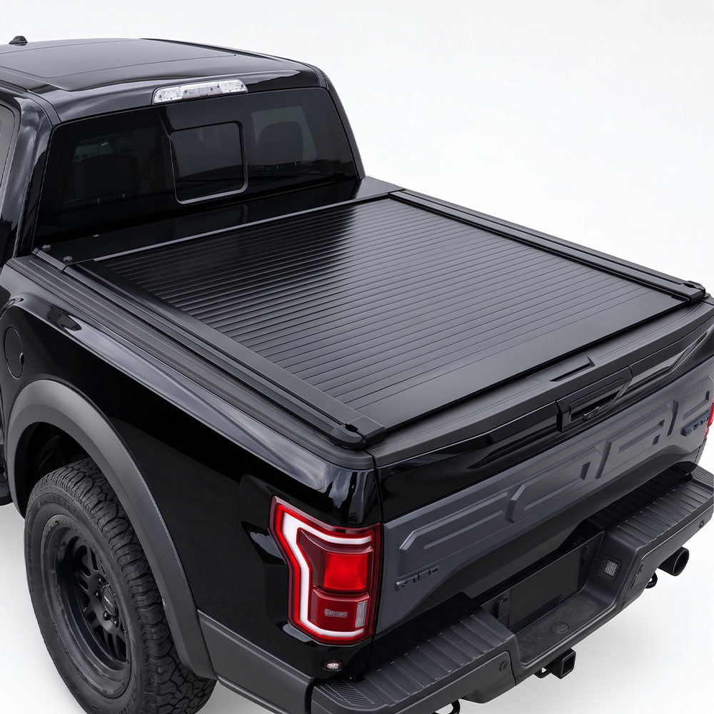 A black truck bed cover installed on the bed of a black pickup truck.