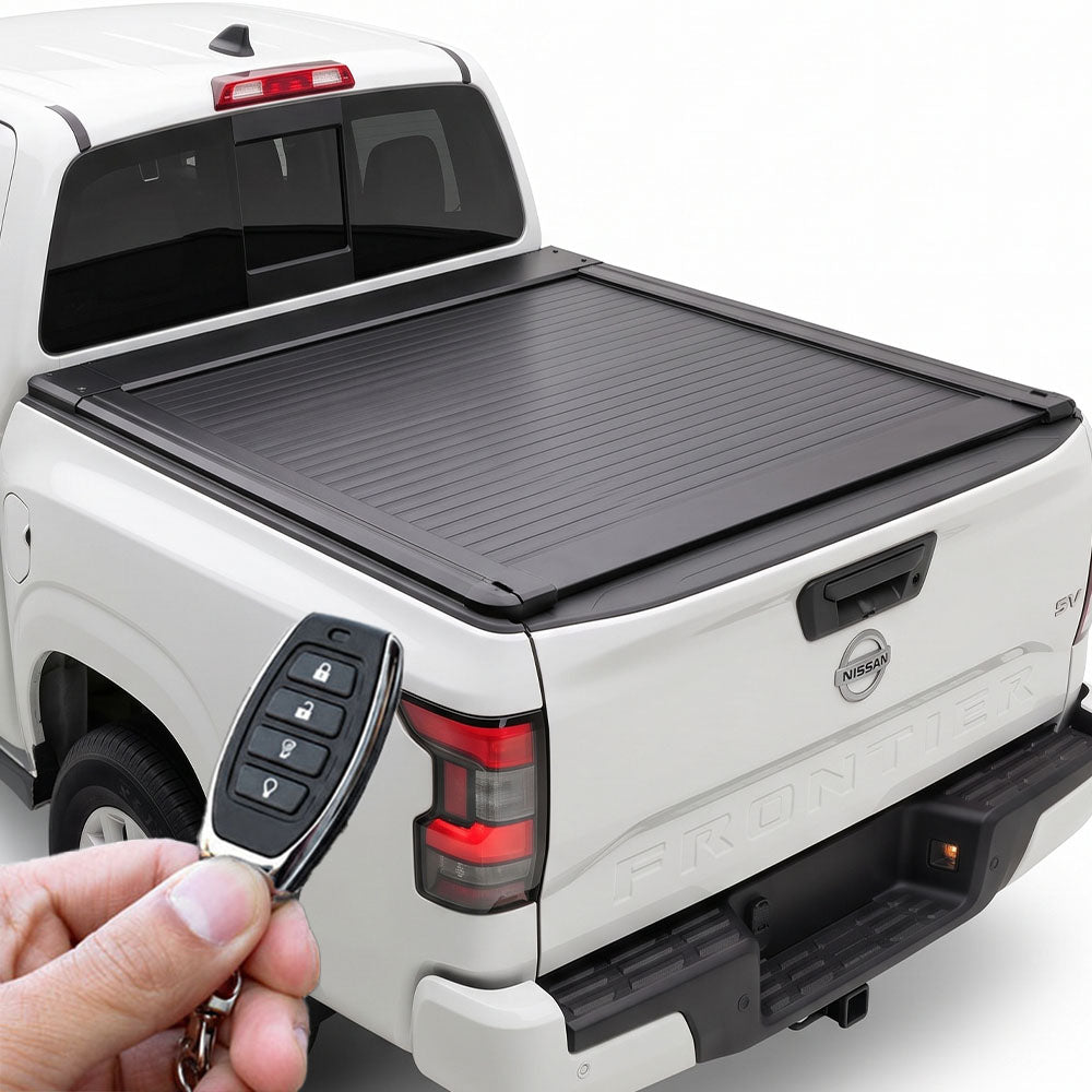 A white Nissan Frontier truck featuring a retractable tonneau cover, shown being operated by a remote held in a hand.