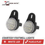 Two black footwell LED lights with clear textured lenses, shown on a white background with the JCWIN AUTO logo and text reading 'COURTESY FOOTWELL LIGHTS', 'WHITE LED', and 'PLUG & PLAY'.