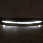 A curved LED light bar mounted on a dark surface, glowing brightly against a dark background.