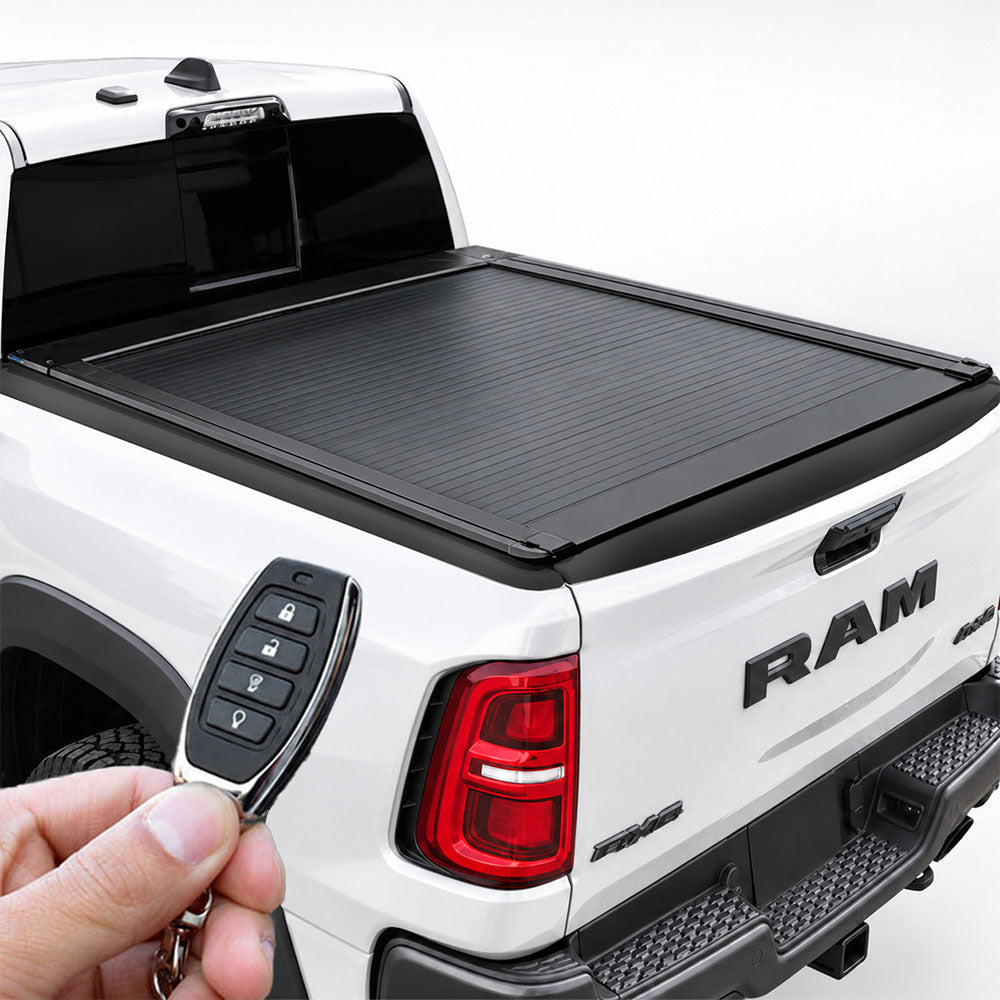 Retractable tonneau cover installed on the bed of a white RAM truck, operated by a key fob remote.
