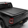 A black tonneau cover installed on the bed of a black Ram pickup truck.
