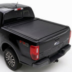 A truck bed cover installed on the bed of a black Ford Ranger pickup truck.
