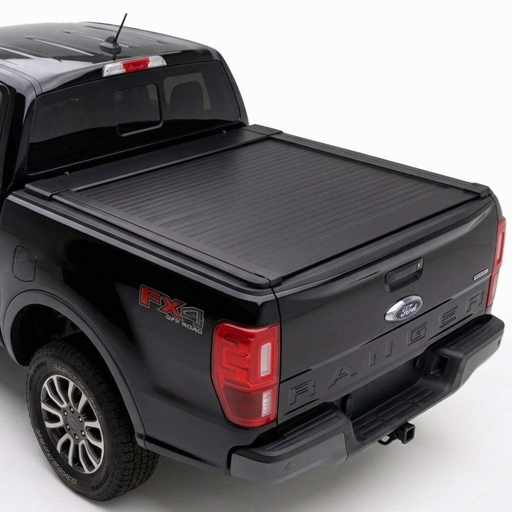 A truck bed cover installed on the bed of a black Ford Ranger pickup truck.
