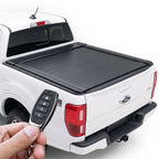 White Ford Ranger truck with a black retractable tonneau cover and remote control.