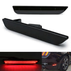 Black glossy car rear bumper LED light bar shown from multiple angles, including a close-up of the illuminated red light bar and a small installed view on a vehicle rear bumper.
