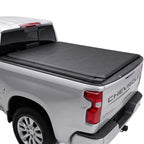 Silver Chevrolet Silverado truck bed with a soft roll up tonneau cover.
