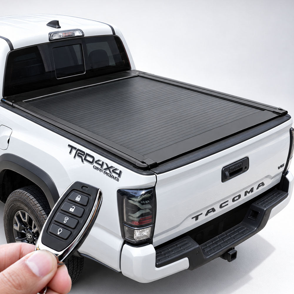 White Toyota Tacoma with closed black retractable tonneau cover, with a remote fob held in the foreground.