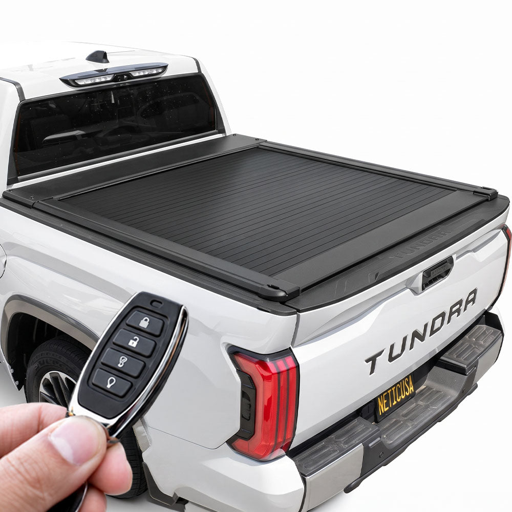 A white Toyota Tundra pickup truck. A hand holds a four-button black key fob remote