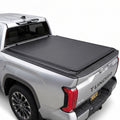 Silver Toyota Tundra truck with a soft roll up tonneau cover on a white background