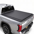 Silver Toyota Tundra truck with a soft roll up tonneau cover on a white background