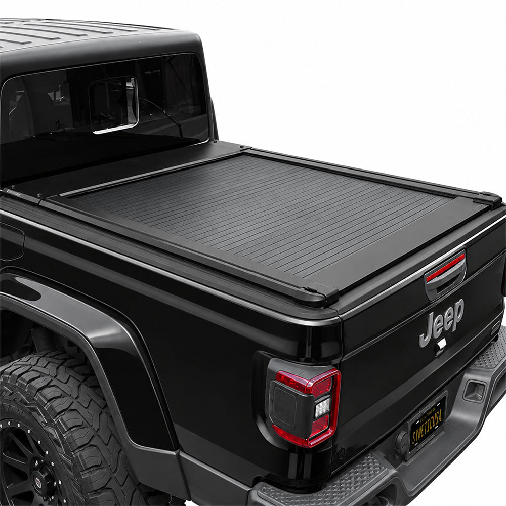 A black retractable bed cover installed on the bed of a black Jeep.
