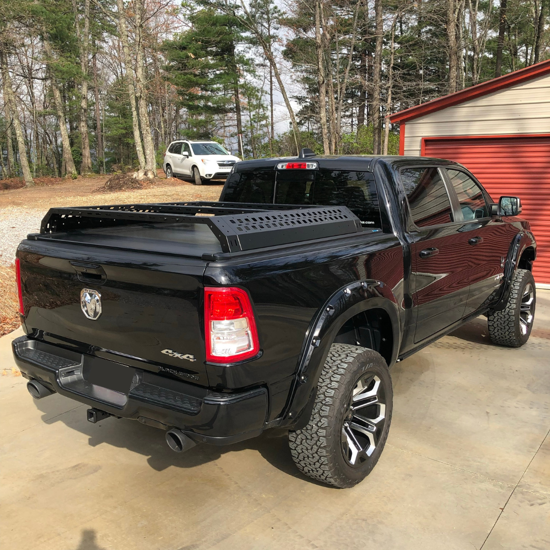 Black pickup truck parked on a driveway with trees and a building in the background
