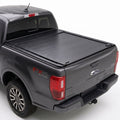 A black retractable truck bed cover installed on the bed of a dark gray Ford Ranger pickup truck.