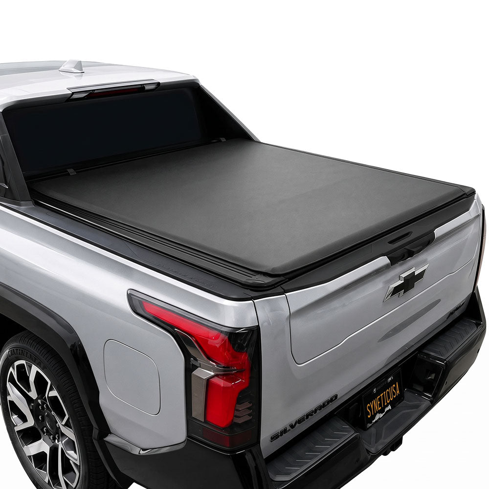 A black soft roll-up tonneau cover installed on the bed of a silver pickup truck